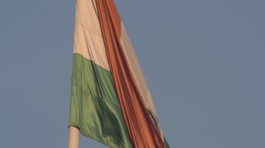India flag flying high at Connaught Place with pride in blue sky, India flag fluttering, Indian Flag on Independence Day and Republic Day of India, tilt up shot, Waving Indian flag, Har Ghar Tiranga