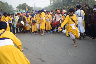 Delhi, Hindistan, 17 Kasım 2024 - Doğu Delhi bölgesinde Guru Nanak Dev, Nagar Kirtan 'ın doğum günü dolayısıyla geleneksel Nagar Kirtan, geleneksel Nagar geçit töreninde Sihler gatka ve dövüş sanatlarını sergiliyor