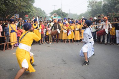 Delhi, Hindistan, 17 Kasım 2024 - Doğu Delhi bölgesinde Guru Nanak Dev, Nagar Kirtan 'ın doğum günü dolayısıyla geleneksel Nagar Kirtan, geleneksel Nagar geçit töreninde Sihler gatka ve dövüş sanatlarını sergiliyor