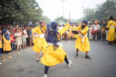 Delhi, Hindistan, 17 Kasım 2024 - Doğu Delhi bölgesinde Guru Nanak Dev, Nagar Kirtan 'ın doğum günü dolayısıyla geleneksel Nagar Kirtan, geleneksel Nagar geçit töreninde Sihler gatka ve dövüş sanatlarını sergiliyor