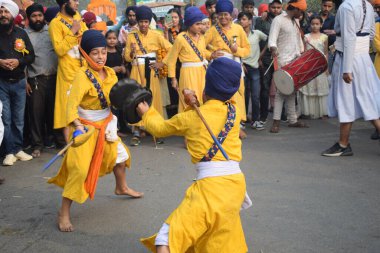 Delhi, Hindistan, 17 Kasım 2024 - Doğu Delhi bölgesinde Guru Nanak Dev, Nagar Kirtan 'ın doğum günü dolayısıyla geleneksel Nagar Kirtan, geleneksel Nagar geçit töreninde Sihler gatka ve dövüş sanatlarını sergiliyor