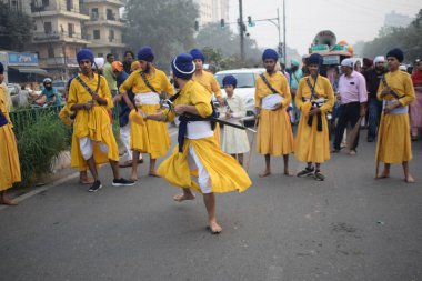 Delhi, Hindistan, 17 Kasım 2024 - Doğu Delhi bölgesinde Guru Nanak Dev, Nagar Kirtan 'ın doğum günü dolayısıyla geleneksel Nagar Kirtan, geleneksel Nagar geçit töreninde Sihler gatka ve dövüş sanatlarını sergiliyor