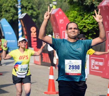 Yeni Delhi, Hindistan - 20 Ekim 2024 - Bitmek üzere olan maraton katılımcılarının bitiş çizgisini geçmek üzere olan Delhi Yarı Maratonu 2024