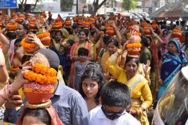 New Delhi, India July 25 2024 - Women with Kalash on head during Jagannath Temple Mangal Kalash Yatra, Indian Hindu devotees carry earthen pots containing sacred water with a coconut on top clipart