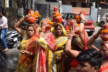 New Delhi, India July 25 2024 - Women with Kalash on head during Jagannath Temple Mangal Kalash Yatra, Indian Hindu devotees carry earthen pots containing sacred water with a coconut on top clipart