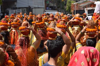 Yeni Delhi, Hindistan 25 Temmuz 2024 - Jagannath Tapınağı sırasında Kalaşlı kadınlar Mangal Kalash Yatra, Hintli Hintli dindarlar üzerinde hindistancevizi olan toprak kapları taşıyorlar