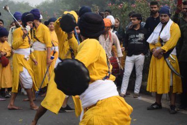 Delhi, Hindistan, 17 Kasım 2024 - Doğu Delhi bölgesinde Guru Nanak Dev, Nagar Kirtan 'ın doğum günü dolayısıyla geleneksel Nagar Kirtan, geleneksel Nagar geçit töreninde Sihler gatka ve dövüş sanatlarını sergiliyor