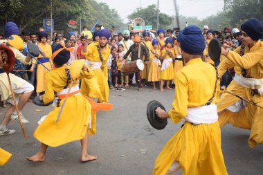 Delhi, Hindistan, 17 Kasım 2024 - Doğu Delhi bölgesinde Guru Nanak Dev, Nagar Kirtan 'ın doğum günü dolayısıyla geleneksel Nagar Kirtan, geleneksel Nagar geçit töreninde Sihler gatka ve dövüş sanatlarını sergiliyor