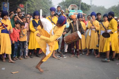 Delhi, Hindistan, 17 Kasım 2024 - Doğu Delhi bölgesinde Guru Nanak Dev, Nagar Kirtan 'ın doğum günü dolayısıyla geleneksel Nagar Kirtan, geleneksel Nagar geçit töreninde Sihler gatka ve dövüş sanatlarını sergiliyor