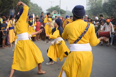Delhi, Hindistan, 17 Kasım 2024 - Doğu Delhi bölgesinde Guru Nanak Dev, Nagar Kirtan 'ın doğum günü dolayısıyla geleneksel Nagar Kirtan, geleneksel Nagar geçit töreninde Sihler gatka ve dövüş sanatlarını sergiliyor