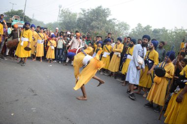 Delhi, Hindistan, 17 Kasım 2024 - Doğu Delhi bölgesinde Guru Nanak Dev, Nagar Kirtan 'ın doğum günü dolayısıyla geleneksel Nagar Kirtan, geleneksel Nagar geçit töreninde Sihler gatka ve dövüş sanatlarını sergiliyor
