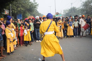Delhi, Hindistan, 17 Kasım 2024 - Doğu Delhi bölgesinde Guru Nanak Dev, Nagar Kirtan 'ın doğum günü dolayısıyla geleneksel Nagar Kirtan, geleneksel Nagar geçit töreninde Sihler gatka ve dövüş sanatlarını sergiliyor