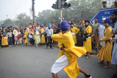 Delhi, Hindistan, 17 Kasım 2024 - Doğu Delhi bölgesinde Guru Nanak Dev, Nagar Kirtan 'ın doğum günü dolayısıyla geleneksel Nagar Kirtan, geleneksel Nagar geçit töreninde Sihler gatka ve dövüş sanatlarını sergiliyor