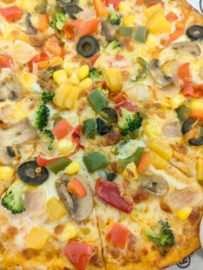 Biberli pizza tahtada, lezzetli ve çıtır vejetaryen pizzanın üst görüntüsü açık kahverengi masa arkasında Margherita.