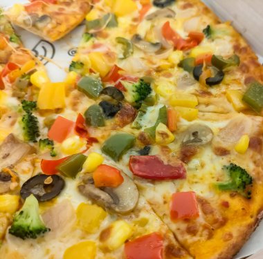 Biberli pizza tahtada, lezzetli ve çıtır vejetaryen pizzanın üst görüntüsü açık kahverengi masa arkasında Margherita.