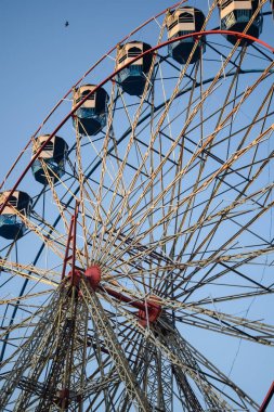 Delhi, Hindistan 'da Dussehra Mela sırasında çok renkli Dev Tekerlek' in yakın çekimi. Dev tekerlek salıncağının alt görüntüsü. Akşam vakti renkli kamaraları olan dönme dolap..