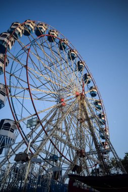 Delhi, Hindistan 'da Dussehra Mela sırasında çok renkli Dev Tekerlek' in yakın çekimi. Dev tekerlek salıncağının alt görüntüsü. Akşam vakti renkli kamaraları olan dönme dolap..