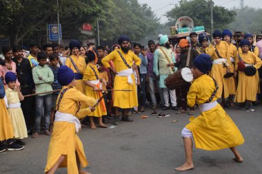 Delhi, Hindistan, 17 Kasım 2024 - Doğu Delhi bölgesinde Guru Nanak Dev, Nagar Kirtan 'ın doğum günü dolayısıyla geleneksel Nagar Kirtan, geleneksel Nagar geçit töreninde Sihler gatka ve dövüş sanatlarını sergiliyor