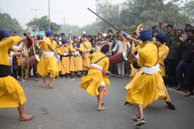 Delhi, Hindistan, 17 Kasım 2024 - Doğu Delhi bölgesinde Guru Nanak Dev, Nagar Kirtan 'ın doğum günü dolayısıyla geleneksel Nagar Kirtan, geleneksel Nagar geçit töreninde Sihler gatka ve dövüş sanatlarını sergiliyor
