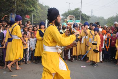 Delhi, Hindistan, 17 Kasım 2024 - Doğu Delhi bölgesinde Guru Nanak Dev, Nagar Kirtan 'ın doğum günü dolayısıyla geleneksel Nagar Kirtan, geleneksel Nagar geçit töreninde Sihler gatka ve dövüş sanatlarını sergiliyor