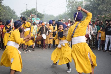 Delhi, Hindistan, 17 Kasım 2024 - Doğu Delhi bölgesinde Guru Nanak Dev, Nagar Kirtan 'ın doğum günü dolayısıyla geleneksel Nagar Kirtan, geleneksel Nagar geçit töreninde Sihler gatka ve dövüş sanatlarını sergiliyor