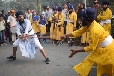 Delhi, Hindistan, 17 Kasım 2024 - Doğu Delhi bölgesinde Guru Nanak Dev, Nagar Kirtan 'ın doğum günü dolayısıyla geleneksel Nagar Kirtan, geleneksel Nagar geçit töreninde Sihler gatka ve dövüş sanatlarını sergiliyor