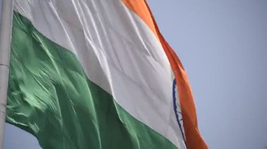 India flag flying high at Connaught Place with pride in blue sky, India flag fluttering, Indian Flag on Independence Day and Republic Day of India, tilt up shot, Waving Indian flag, Har Ghar Tiranga