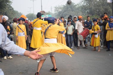 Delhi, Hindistan, 17 Kasım 2024 - Doğu Delhi bölgesinde Guru Nanak Dev, Nagar Kirtan 'ın doğum günü dolayısıyla geleneksel Nagar Kirtan, geleneksel Nagar geçit töreninde Sihler gatka ve dövüş sanatlarını sergiliyor