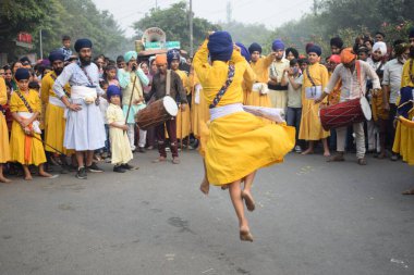 Delhi, Hindistan, 17 Kasım 2024 - Doğu Delhi bölgesinde Guru Nanak Dev, Nagar Kirtan 'ın doğum günü dolayısıyla geleneksel Nagar Kirtan, geleneksel Nagar geçit töreninde Sihler gatka ve dövüş sanatlarını sergiliyor
