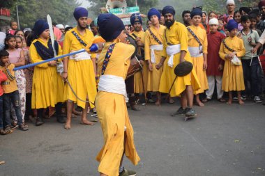 Delhi, Hindistan, 17 Kasım 2024 - Doğu Delhi bölgesinde Guru Nanak Dev, Nagar Kirtan 'ın doğum günü dolayısıyla geleneksel Nagar Kirtan, geleneksel Nagar geçit töreninde Sihler gatka ve dövüş sanatlarını sergiliyor