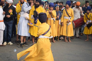 Delhi, Hindistan, 17 Kasım 2024 - Doğu Delhi bölgesinde Guru Nanak Dev, Nagar Kirtan 'ın doğum günü dolayısıyla geleneksel Nagar Kirtan, geleneksel Nagar geçit töreninde Sihler gatka ve dövüş sanatlarını sergiliyor