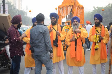 Delhi, Hindistan, 17 Kasım 2024 - Doğu Delhi bölgesinde Guru Nanak Dev, Nagar Kirtan 'ın doğum günü dolayısıyla geleneksel Nagar Kirtan, geleneksel Nagar geçit töreninde Sihler gatka ve dövüş sanatlarını sergiliyor