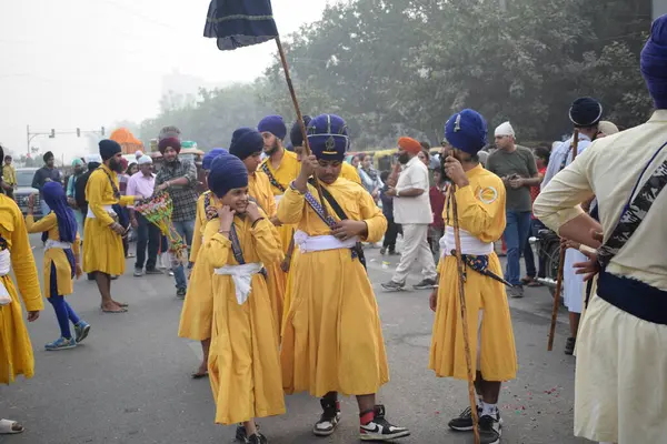 Delhi, Hindistan, 17 Kasım 2024 - Doğu Delhi bölgesinde Guru Nanak Dev, Nagar Kirtan 'ın doğum günü dolayısıyla geleneksel Nagar Kirtan, geleneksel Nagar geçit töreninde Sihler gatka ve dövüş sanatlarını sergiliyor