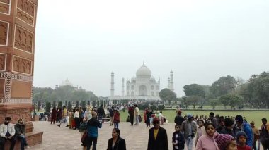 Agra, Uttar Pradesh, Hindistan - 31 Aralık 2024 - İnsanlar Tac Mahal 'i yedi dünya harikası arasında ziyaret ediyorlar. Bulutlu bir günde ünlü Hint İslami mirası, Taj Mahal Yamuna Nehri 'nin güney kıyısında yer alıyor.