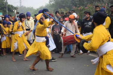 Delhi, Hindistan, 17 Kasım 2024 - Doğu Delhi bölgesinde Guru Nanak Dev, Nagar Kirtan 'ın doğum günü dolayısıyla geleneksel Nagar Kirtan, geleneksel Nagar geçit töreninde Sihler gatka ve dövüş sanatlarını sergiliyor