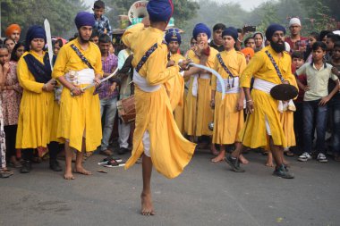 Delhi, Hindistan, 17 Kasım 2024 - Doğu Delhi bölgesinde Guru Nanak Dev, Nagar Kirtan 'ın doğum günü dolayısıyla geleneksel Nagar Kirtan, geleneksel Nagar geçit töreninde Sihler gatka ve dövüş sanatlarını sergiliyor