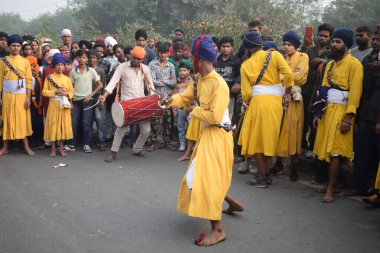 Delhi, Hindistan, 17 Kasım 2024 - Doğu Delhi bölgesinde Guru Nanak Dev, Nagar Kirtan 'ın doğum günü dolayısıyla geleneksel Nagar Kirtan, geleneksel Nagar geçit töreninde Sihler gatka ve dövüş sanatlarını sergiliyor