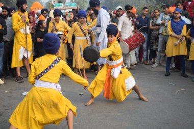 Delhi, Hindistan, 17 Kasım 2024 - Doğu Delhi bölgesinde Guru Nanak Dev, Nagar Kirtan 'ın doğum günü dolayısıyla geleneksel Nagar Kirtan, geleneksel Nagar geçit töreninde Sihler gatka ve dövüş sanatlarını sergiliyor