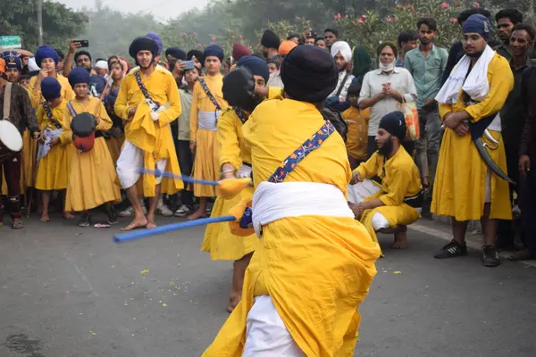 Delhi, Hindistan, 17 Kasım 2024 - Doğu Delhi bölgesinde Guru Nanak Dev, Nagar Kirtan 'ın doğum günü dolayısıyla geleneksel Nagar Kirtan, geleneksel Nagar geçit töreninde Sihler gatka ve dövüş sanatlarını sergiliyor