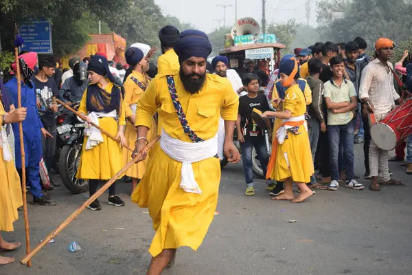 Delhi, Hindistan, 17 Kasım 2024 - Doğu Delhi bölgesinde Guru Nanak Dev, Nagar Kirtan 'ın doğum günü dolayısıyla geleneksel Nagar Kirtan, geleneksel Nagar geçit töreninde Sihler gatka ve dövüş sanatlarını sergiliyor