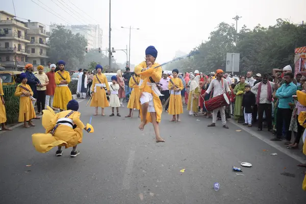 Delhi, Hindistan, 17 Kasım 2024 - Doğu Delhi bölgesinde Guru Nanak Dev, Nagar Kirtan 'ın doğum günü dolayısıyla geleneksel Nagar Kirtan, geleneksel Nagar geçit töreninde Sihler gatka ve dövüş sanatlarını sergiliyor