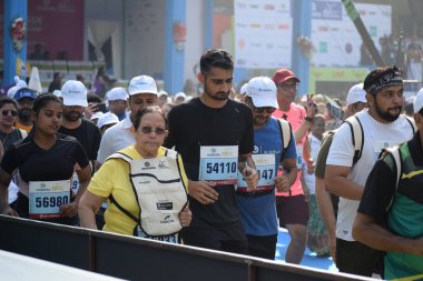 Yeni Delhi, Hindistan - 20 Ekim 2024 - Bitmek üzere olan maraton katılımcılarının bitiş çizgisini geçmek üzere olan Delhi Yarı Maratonu 2024