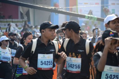 Yeni Delhi, Hindistan - 20 Ekim 2024 - Bitmek üzere olan maraton katılımcılarının bitiş çizgisini geçmek üzere olan Delhi Yarı Maratonu 2024