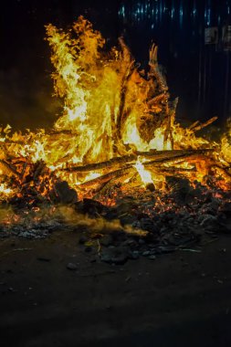 Siyah arka planda alevler, alev alev dokusu arka planda, çok güzel, ateş yanıyor, ateş odun ve inek gübresi ateşiyle yanıyor.
