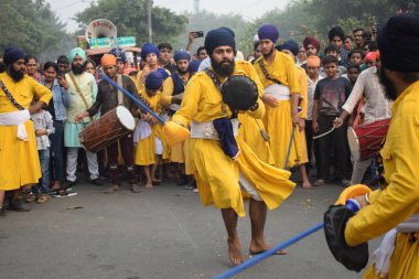 Delhi, Hindistan, 17 Kasım 2024 - Doğu Delhi bölgesinde Guru Nanak Dev, Nagar Kirtan 'ın doğum günü dolayısıyla geleneksel Nagar Kirtan, geleneksel Nagar geçit töreninde Sihler gatka ve dövüş sanatlarını sergiliyor