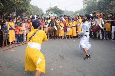 Delhi, Hindistan, 17 Kasım 2024 - Doğu Delhi bölgesinde Guru Nanak Dev, Nagar Kirtan 'ın doğum günü dolayısıyla geleneksel Nagar Kirtan, geleneksel Nagar geçit töreninde Sihler gatka ve dövüş sanatlarını sergiliyor