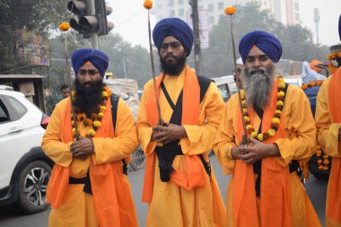 Delhi, Hindistan, 17 Kasım 2024 - Doğu Delhi bölgesinde Guru Nanak Dev, Nagar Kirtan 'ın doğum günü dolayısıyla geleneksel Nagar Kirtan, geleneksel Nagar geçit töreninde Sihler gatka ve dövüş sanatlarını sergiliyor