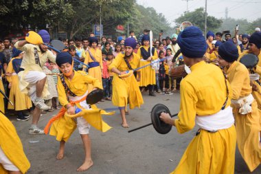 Delhi, Hindistan, 17 Kasım 2024 - Doğu Delhi bölgesinde Guru Nanak Dev, Nagar Kirtan 'ın doğum günü dolayısıyla geleneksel Nagar Kirtan, geleneksel Nagar geçit töreninde Sihler gatka ve dövüş sanatlarını sergiliyor