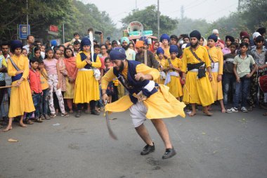 Delhi, Hindistan, 17 Kasım 2024 - Doğu Delhi bölgesinde Guru Nanak Dev, Nagar Kirtan 'ın doğum günü dolayısıyla geleneksel Nagar Kirtan, geleneksel Nagar geçit töreninde Sihler gatka ve dövüş sanatlarını sergiliyor