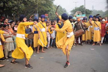Delhi, Hindistan, 17 Kasım 2024 - Doğu Delhi bölgesinde Guru Nanak Dev, Nagar Kirtan 'ın doğum günü dolayısıyla geleneksel Nagar Kirtan, geleneksel Nagar geçit töreninde Sihler gatka ve dövüş sanatlarını sergiliyor